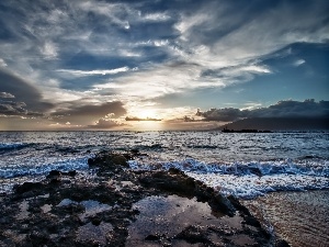 Waves, clouds, rocks, sea